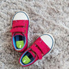 Red kids sneakers with left and right shoe labels
